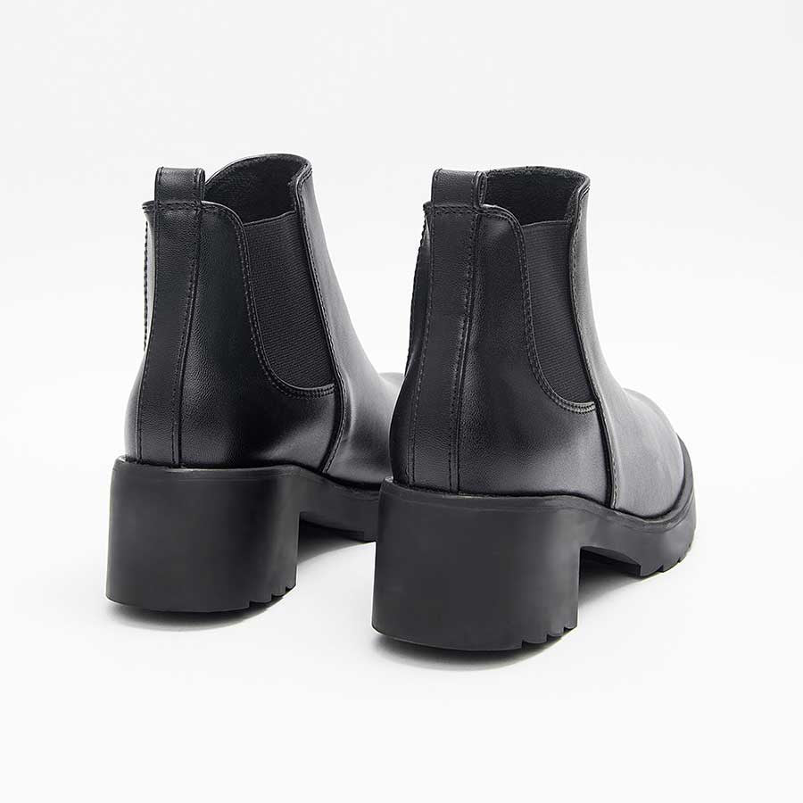 Botines para dama 1738, de color negro. Están fabricados en cuero sintético, son de caña baja y tacón bajito. Y tienen elásticos en los laterales.Los zapatos se ven desde atrás y puestos sobre un fondo blanco.