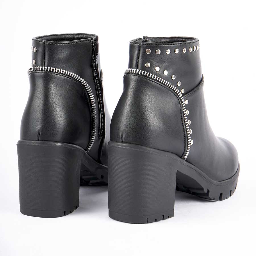 Botines para dama 262, de color negro. Están fabricados en cuero sintético, son de caña media y tacón medio. Y tienen accesorios plateados como taches, herrajes y cierre Los zapatos se ven desde atrás y puestos sobre un fondo blanco.