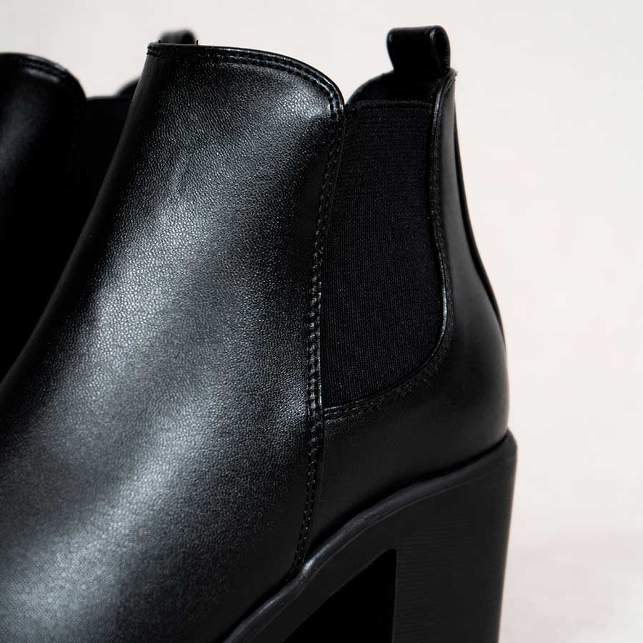 Acercamiento de los Botines de mujer negros lucy. Muestra la textura del cuero sintético, las costuras y los elásticos en los laterales 