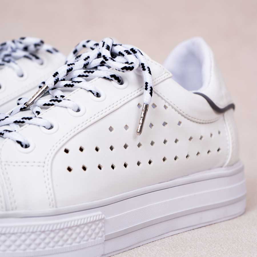 Acercamiento de los tenis de mujer blancos 633. Muestra la textura del cuero sintético, las costuras y los accesorios  como cordones 